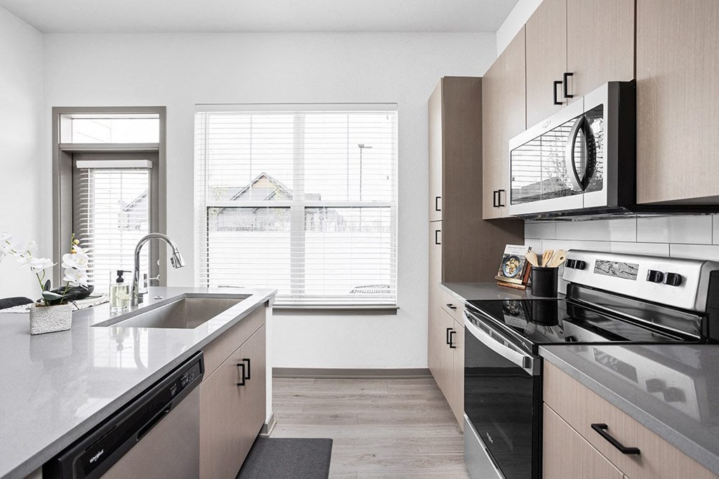 a kitchen with a sink and stove and a window