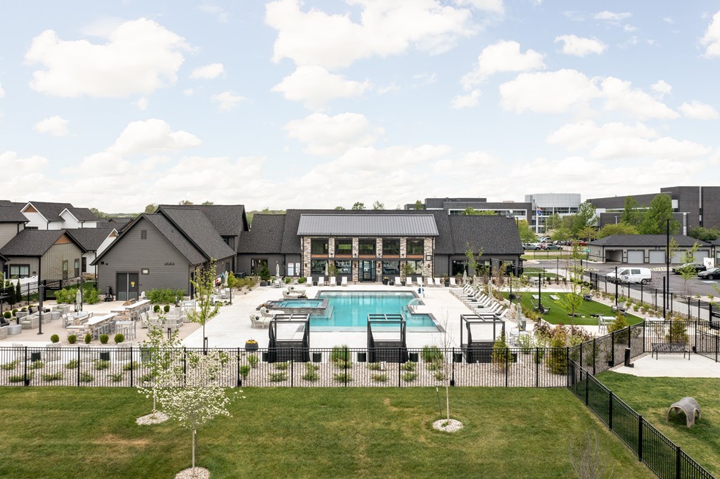 an aerial view of an outdoor pool with a building in the background