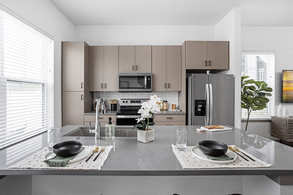 a kitchen with a large island and stainless steel appliances