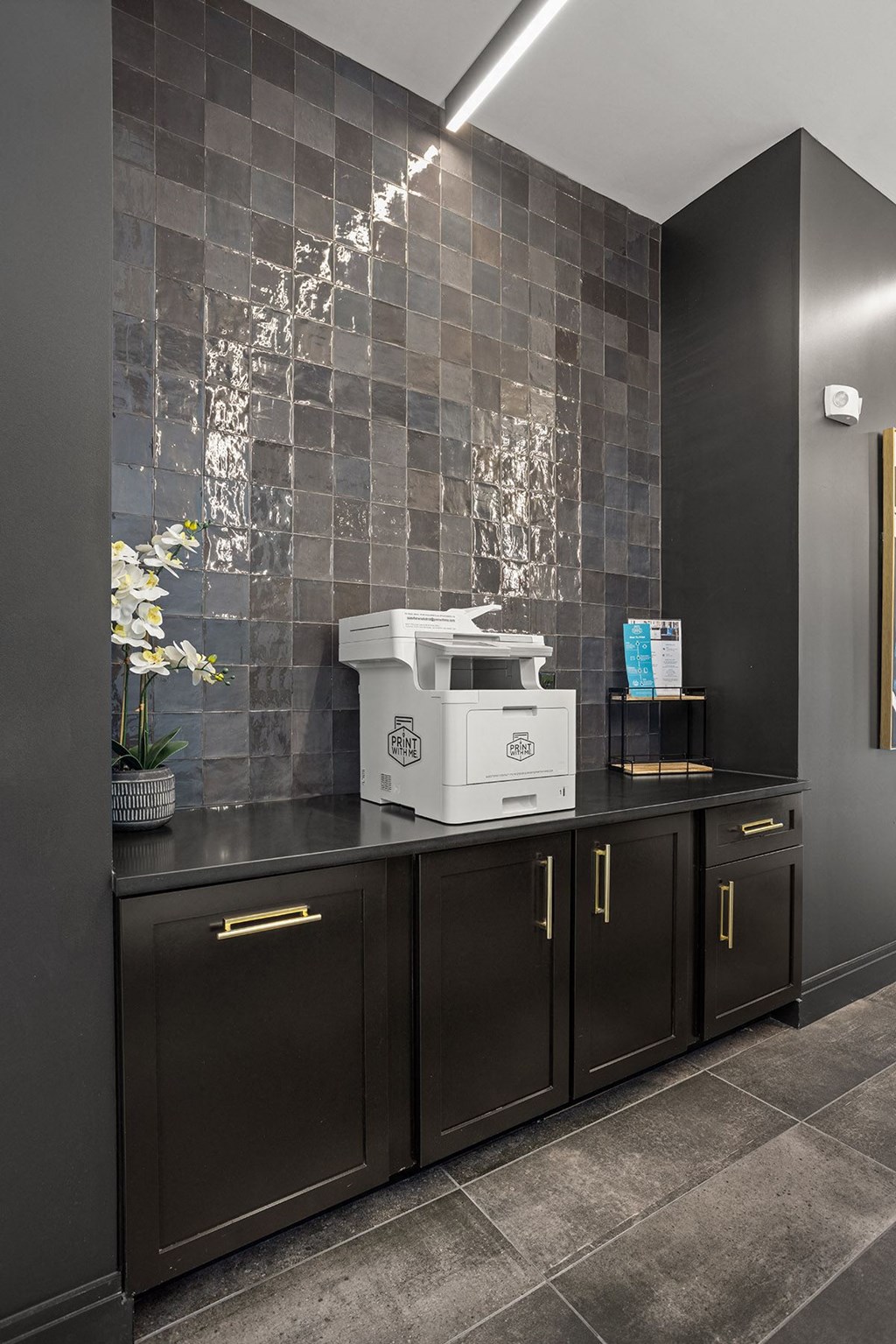 a counter with a white toaster on it in a room with black cabinets