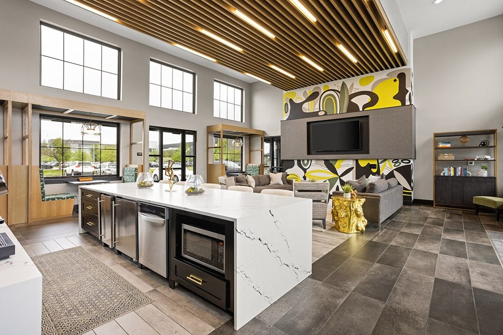 a kitchen with a marble counter top and a living room with a tv