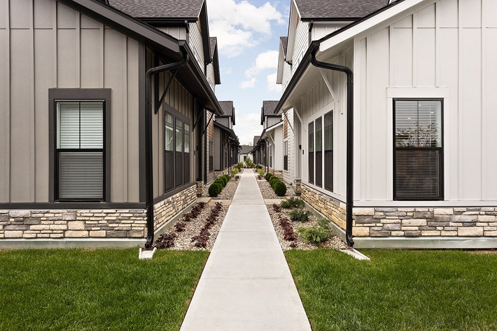 a row of houses with a sidewalk and grass
