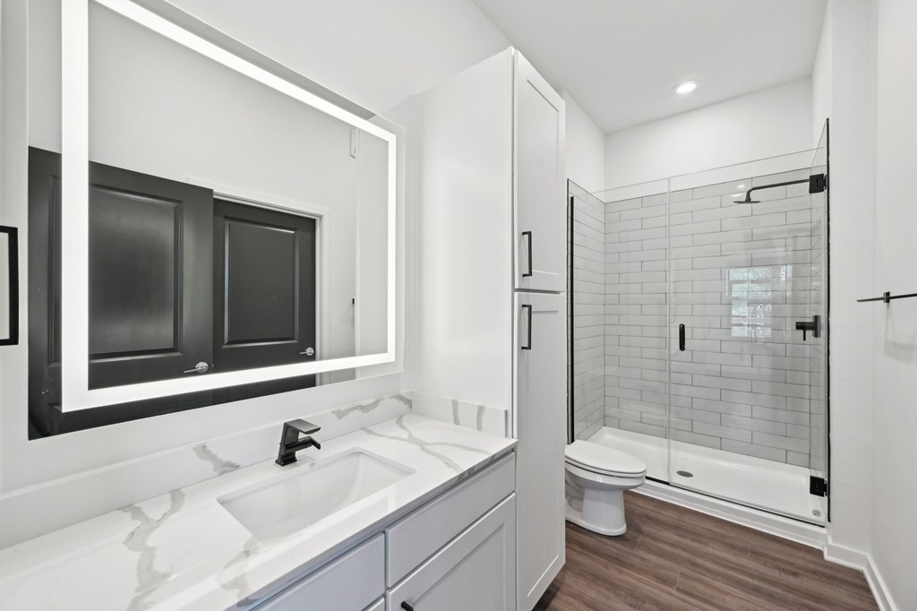 A modern bathroom with a white sink and a walk-in shower at The Concord Luxury Apartments, Sarasota, Florida