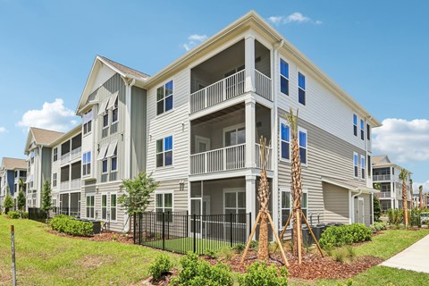 A large two-story apartment building with a balcony on the second floor.