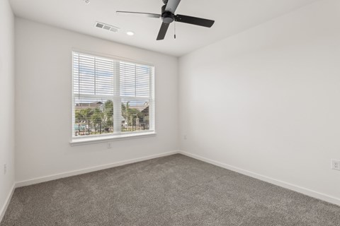 A room with a ceiling fan and a window with blinds at The Junction at Rockledge Apartments, Rockledge, Florida