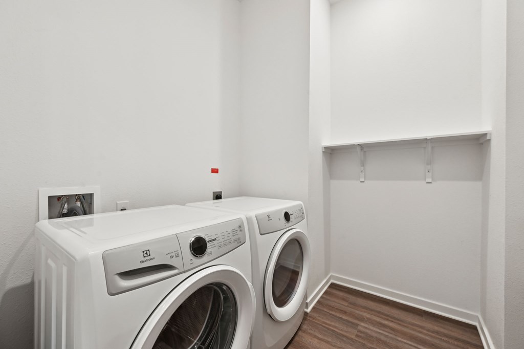 A white washing machine and dryer in a laundry room at The Concord Luxury Apartments, Florida