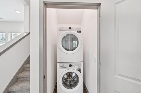 A white washing machine and dryer in a small laundry room at The Hadley - North Port, FL Apartments, North Port, FL, 34287