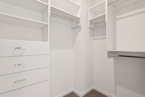 A white walk-in closet with shelves and drawers at The Junction at Rockledge Apartments, Rockledge