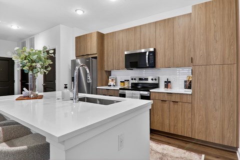 A modern kitchen with wooden cabinets and a white countertop.