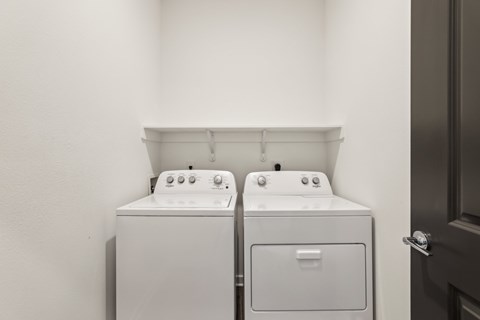 Two white washing machines in a laundry room. at The Junction at Rockledge Apartments, Rockledge, FL