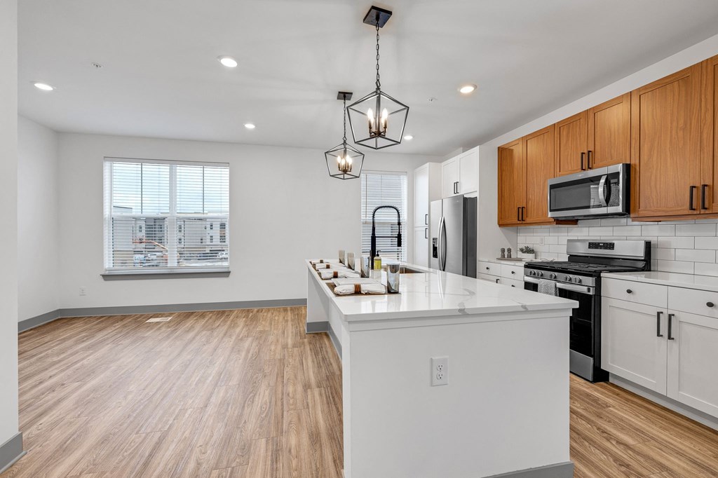 an open kitchen with a large island with a white counter top at Meridian at CityPlace, Minnesota