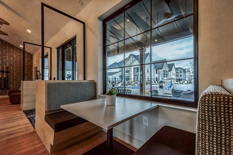 a dining room with a large window and a table at The BLVD at Wilson Crossings, Michigan, 49418