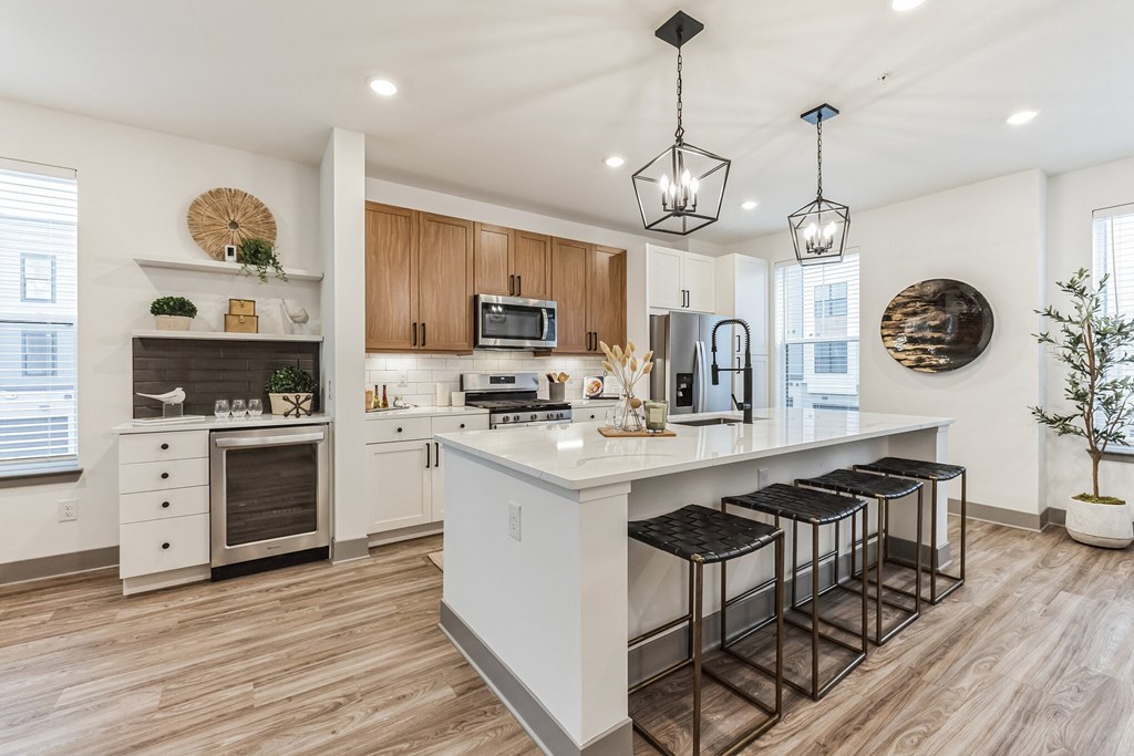 an open kitchen with a large island with bar stools at Meridian at CityPlace, Minnesota