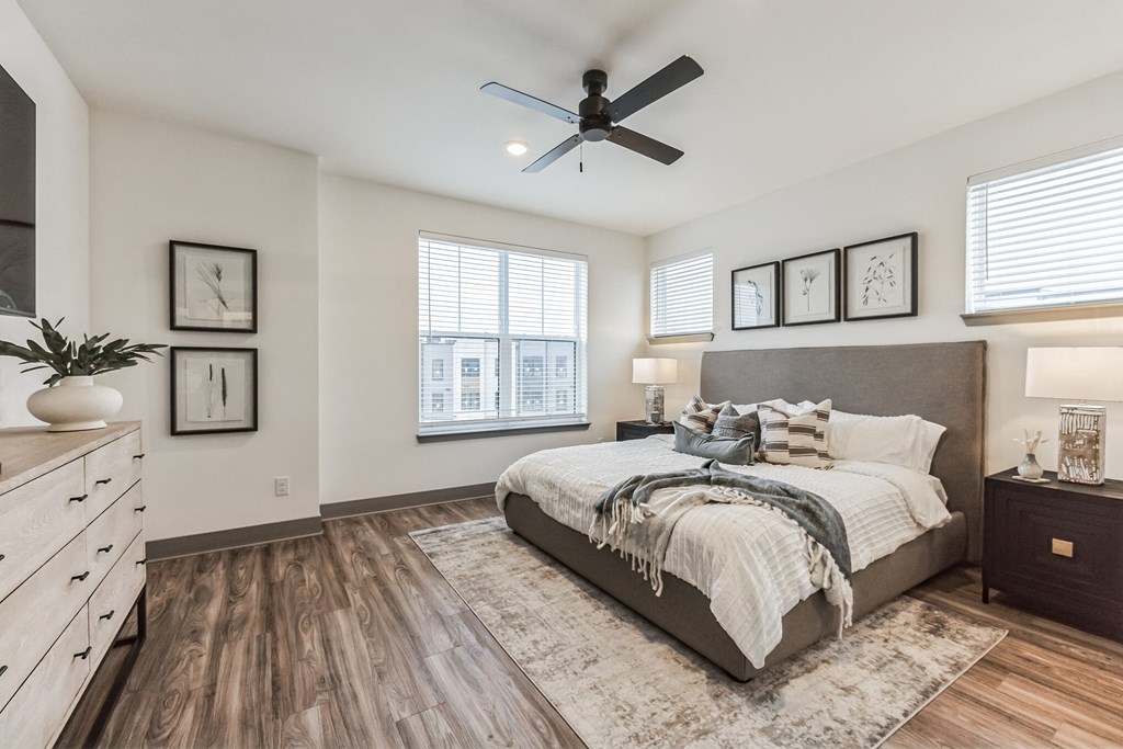the master bedroom in a new home with a large bed and a ceiling fan at Meridian at CityPlace, Woodbury Minnesota