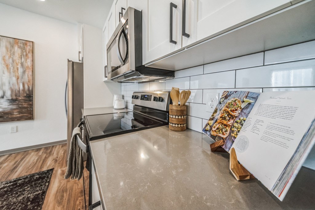 an updated kitchen with stainless steel appliances and white cabinets at The BLVD at Wilson Crossings, Michigan