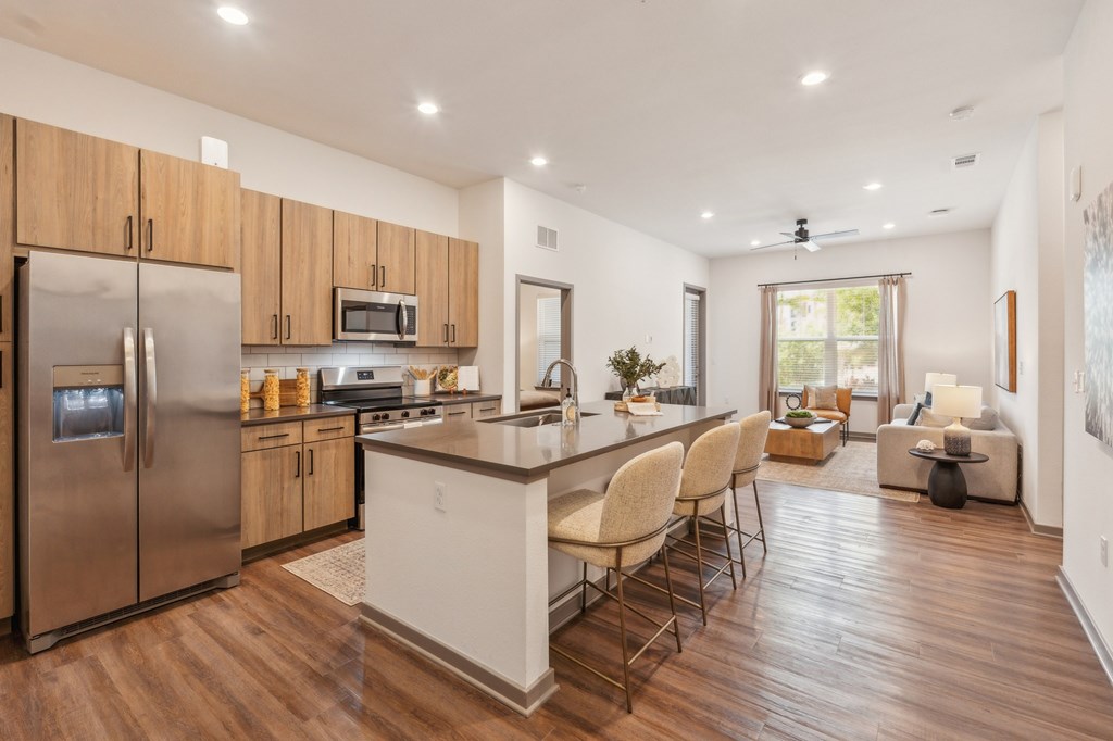A modern kitchen with wooden cabinets and a stainless steel refrigerator at The Concord Luxury Apartments, Florida, 34240