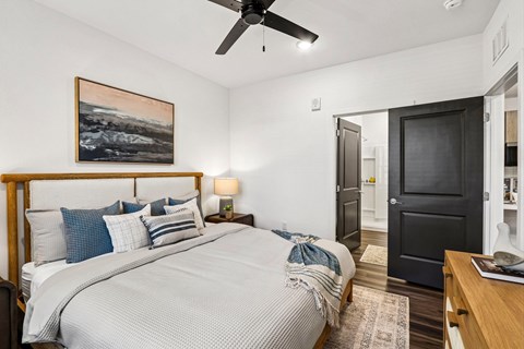 A bedroom with a large bed and a ceiling fan.