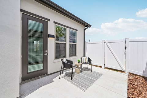A white house with a grey door and a grey and white rug in front at The Hadley - North Port, FL Apartments, North Port, FL, 34287