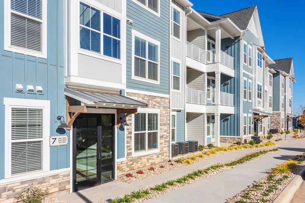 an apartment building with a sidewalk in front of it  at Taylor Farms, Charlotte, 28262