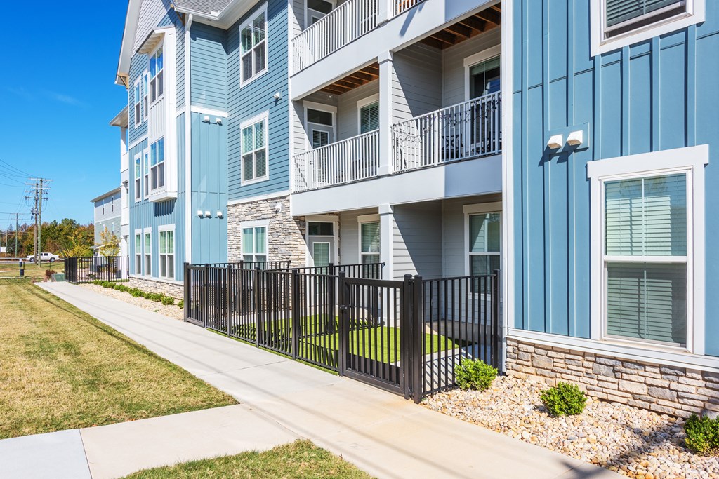 an apartment building with blue exterior walls and a sidewalk  at Taylor Farms, Charlotte