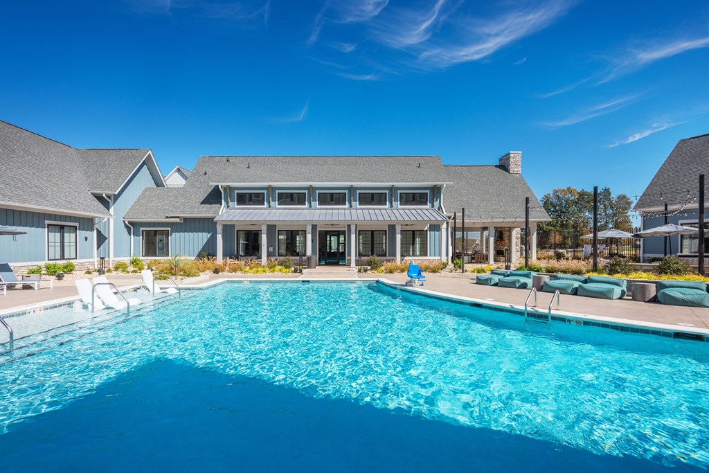 a large swimming pool with a house in the background  at Taylor Farms, Charlotte