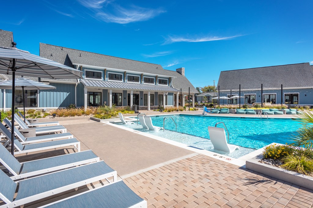 a swimming pool with chairs and umbrellas at a resort  at Taylor Farms, Charlotte, 28262
