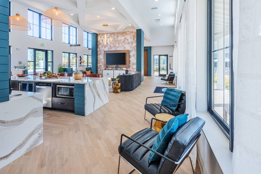a living room with blue chairs and a kitchen and a television  at Taylor Farms, North Carolina, 28262