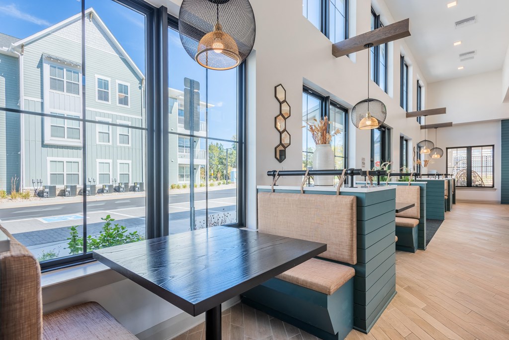 a dining area with a table and chairs and large windows  at Taylor Farms, Charlotte, North Carolina