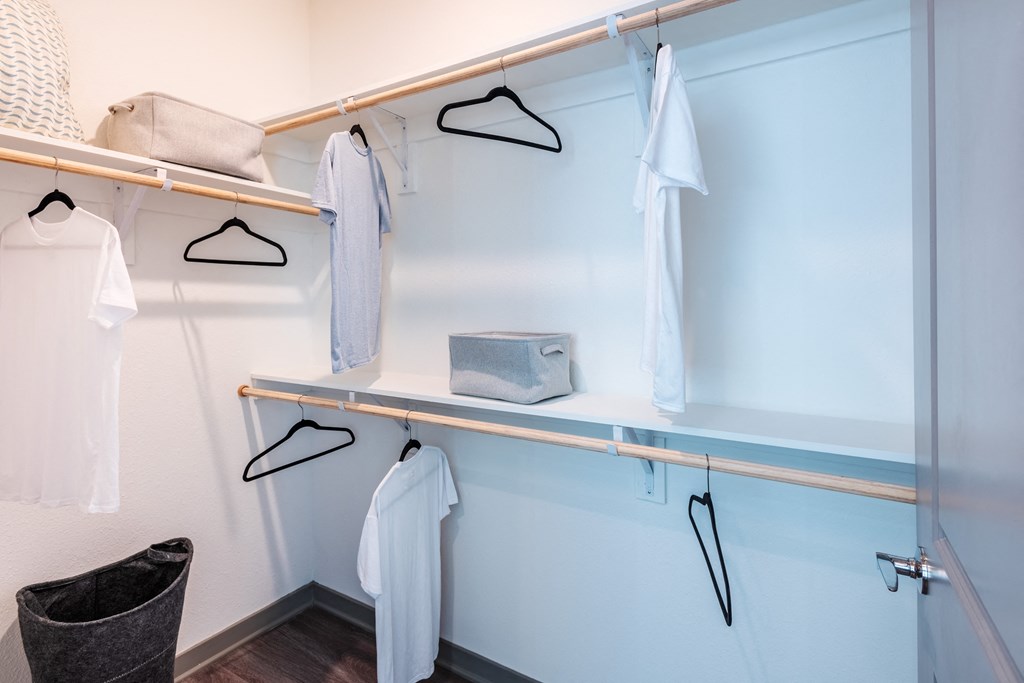 a walk in closet with a blue wall and shelves with white robes and hangers  at Taylor Farms, North Carolina