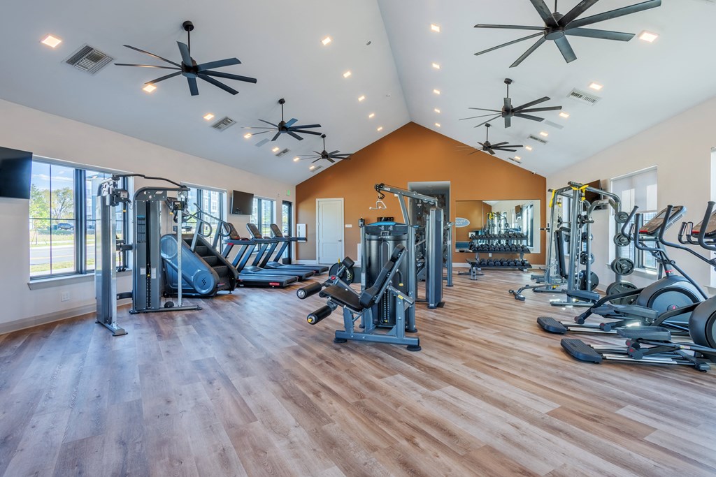 a gym with cardio machines and weights on the floor and a large window  at Taylor Farms, North Carolina, 28262
