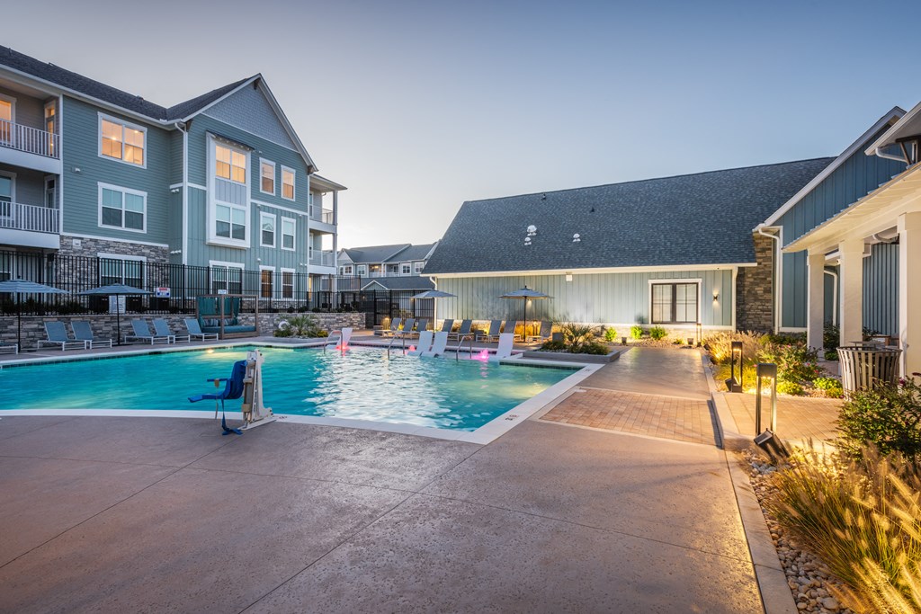 a swimming pool at night in front of an apartment building  at Taylor Farms, Charlotte, 28262