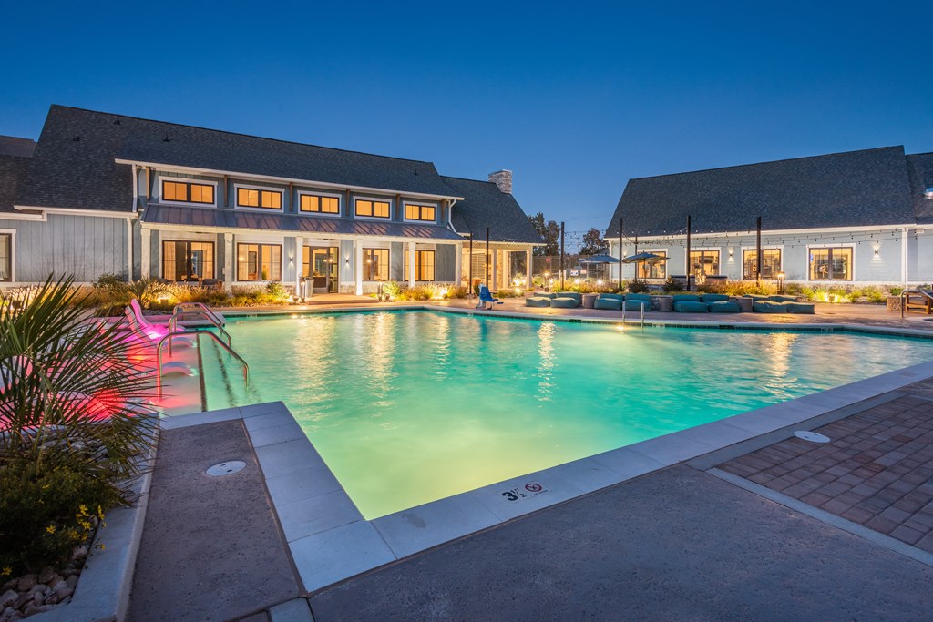 a large swimming pool in front of a house at night  at Taylor Farms, Charlotte