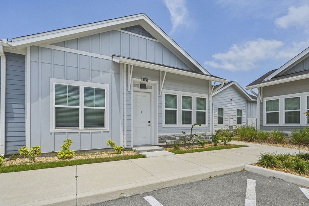 A row of houses with a grey facade and white trim. at The Sophia, Venice, FL, 34275