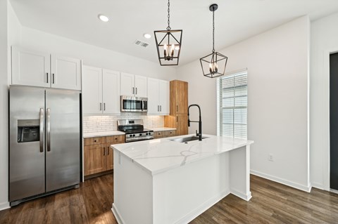 A modern kitchen with a white island and stainless steel appliances. at The Hadley - North Port, FL Apartments, North Port, FL