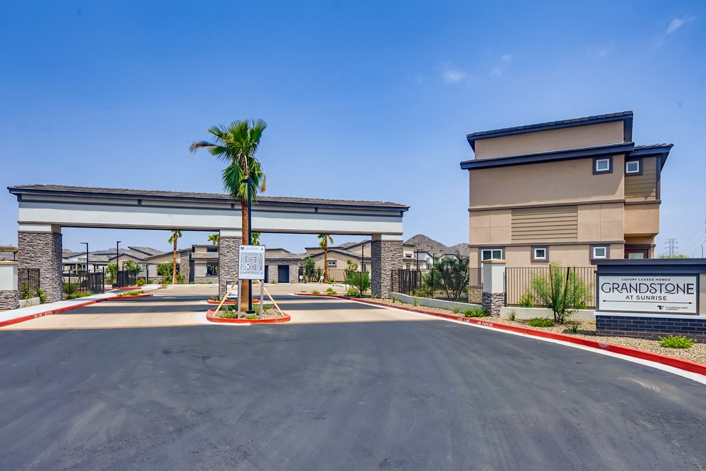 a building with a palm tree in front of a parking lot at Grandstone at Sunrise, Arizona
