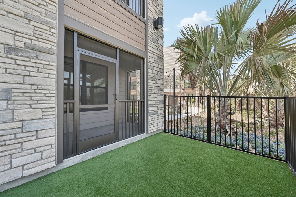 A patio with a black fence and a glass door at The Concord Luxury Apartments, Sarasota, Florida