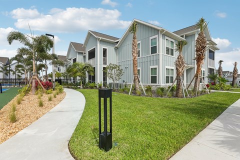 A modern house with a white exterior and a black pole in front of it at The Junction at Rockledge Apartments, Rockledge 32955