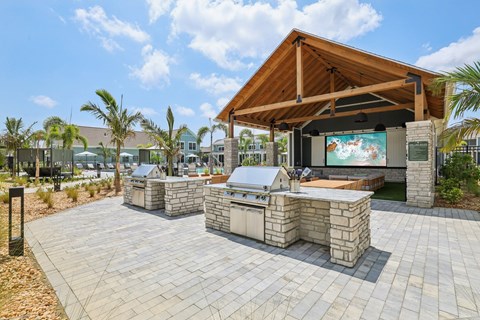 A patio with a stone table and a wooden roofed pavilion at The Junction at Rockledge Apartments, Rockledge, FL