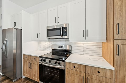 A kitchen with a stainless steel refrigerator, microwave, and oven at The Hadley - North Port, FL Apartments, North Port