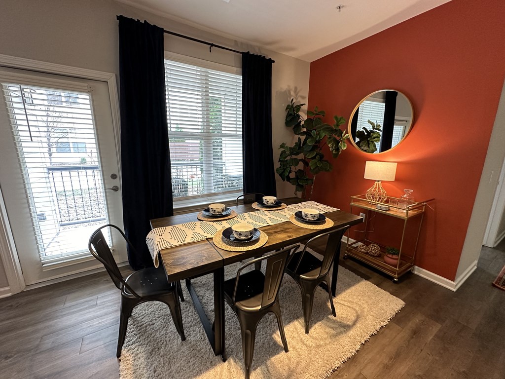 a dining room with an orange wall and a table and chairs at Watermark at Steele Crossing, Arkansas, 72703
