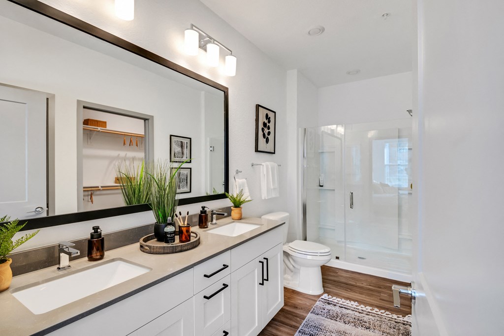 a bathroom with a large mirror and a toilet and a shower at The BLVD at Wilson Crossings, Wyoming, MI 49418