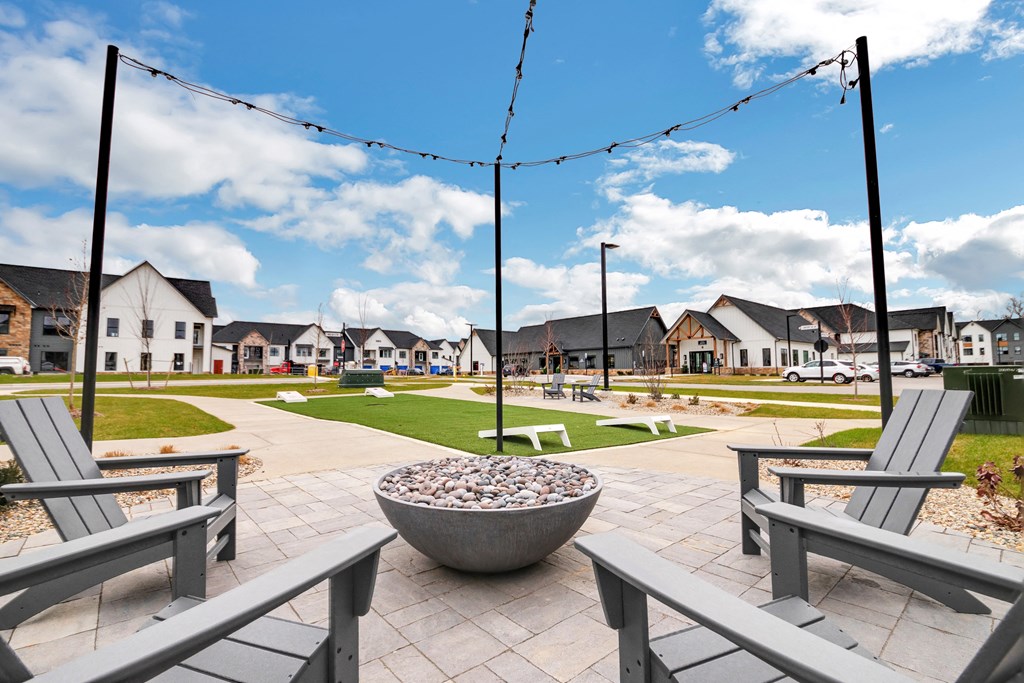 a park with benches and fire pits with houses in the background at The BLVD at Wilson Crossings, Wyoming, 49418