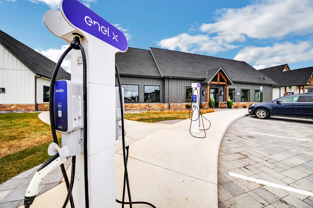 an electric car charging station in front of a house at The BLVD at Wilson Crossings, Michigan, 49418
