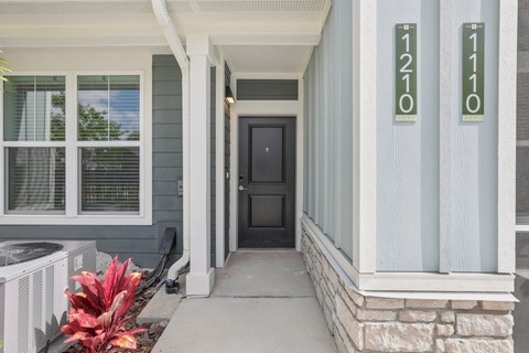 A black door is on the right side of a white column at The Junction at Rockledge Apartments, Rockledge, FL