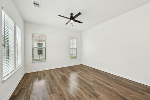 A room with a ceiling fan and two windows at The Hadley - North Port, FL Apartments, Florida