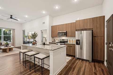 A modern kitchen with a white island and stainless steel appliances.