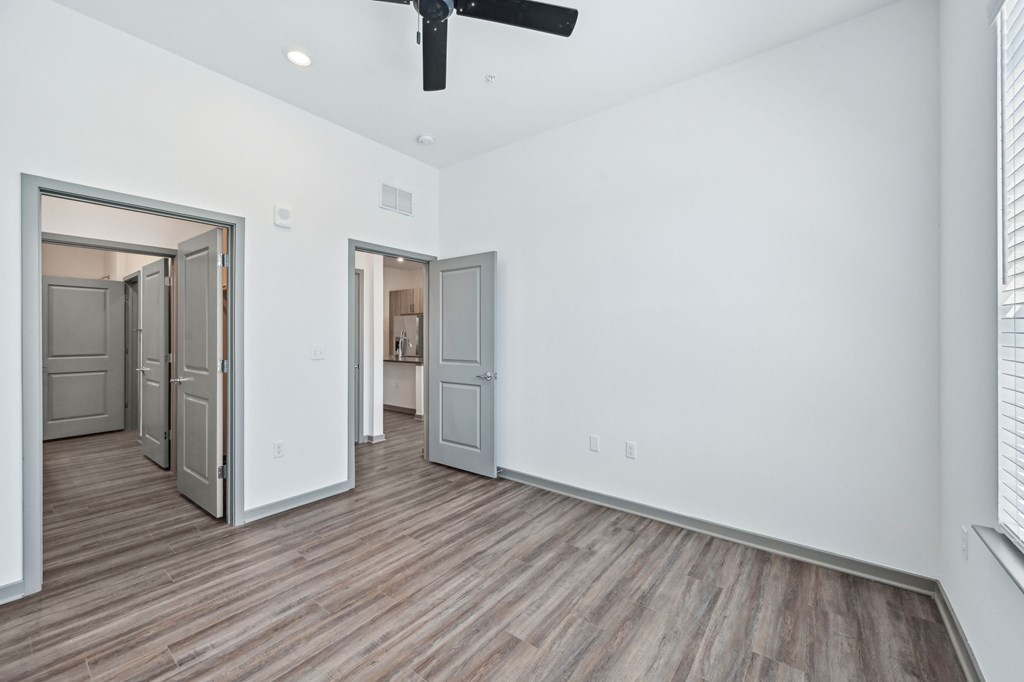 A room with a ceiling fan and wooden flooring at The Concord Luxury Apartments, Sarasota, FL