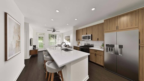 A modern kitchen with a long white island and stainless steel appliances.
