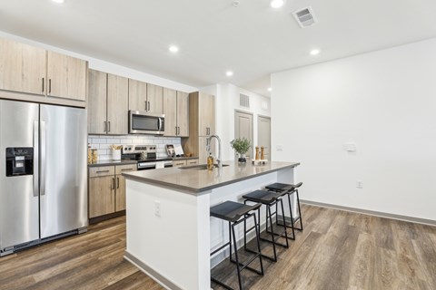 A kitchen with a refrigerator, microwave, and stove top oven. at The Junction at Rockledge Apartments, Rockledge, FL, 32955