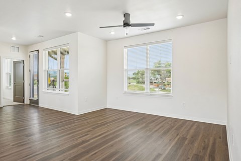 A room with a ceiling fan and a window with blinds.